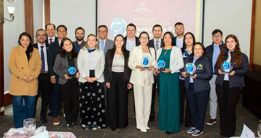 Hombres y mujeres posando para la foto con sus premios en las manos.