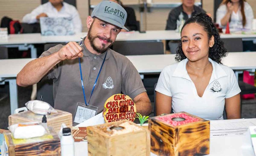Hombre, con gorra, y mujer posando para la foto junto a sus productos.