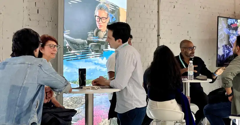 Personas dialogando y haciendo negocios en mesas, en medio de gran salón. - Colombia llega a Madrid con más de 50 empresas para atraer  inversión audiovisual