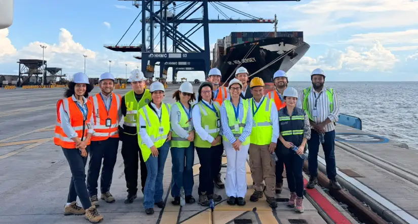 Personas, con elementos de seguridad, posando para la foto, de pie, en medio de puerto con barco atrás. - Mincomercio articula a ICA, DIAN, Invima y Antinarcóticos para agilizar las exportaciones desde Puerto Antioquia 