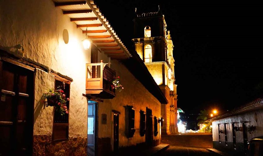 Descripción de la imagen: Foto de las fachadas de casas y la iglesia de Barichara, de noche.