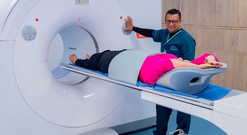 Enfermero introduciendo a mujer paciente en escáner de TC.