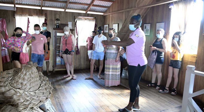 Un grupo de personas escuchan a una mujer guía turística.