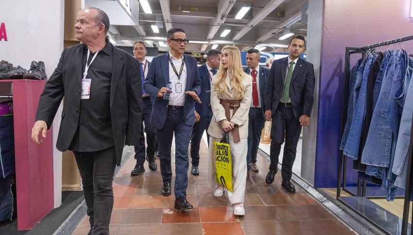 Ministra Diana Morales, junto a varios hombres, caminando por pasillo de la feria Createx.