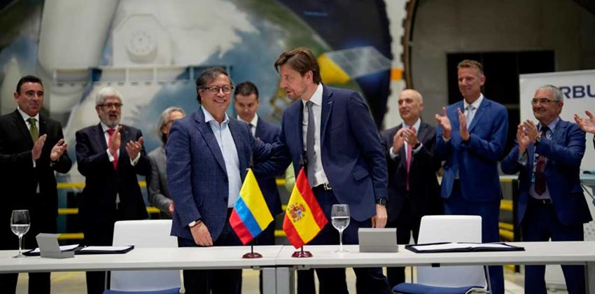 Nueve personas representantes de los gobiernos de Colombia y España aplauden.