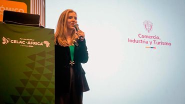 Sofía Cañón hablando por micrófono desde el escenario, con el logo del MinCIT al fondo. - Colombia presentó a empresarios privados la Ventanilla Única de Inversión (VUI)