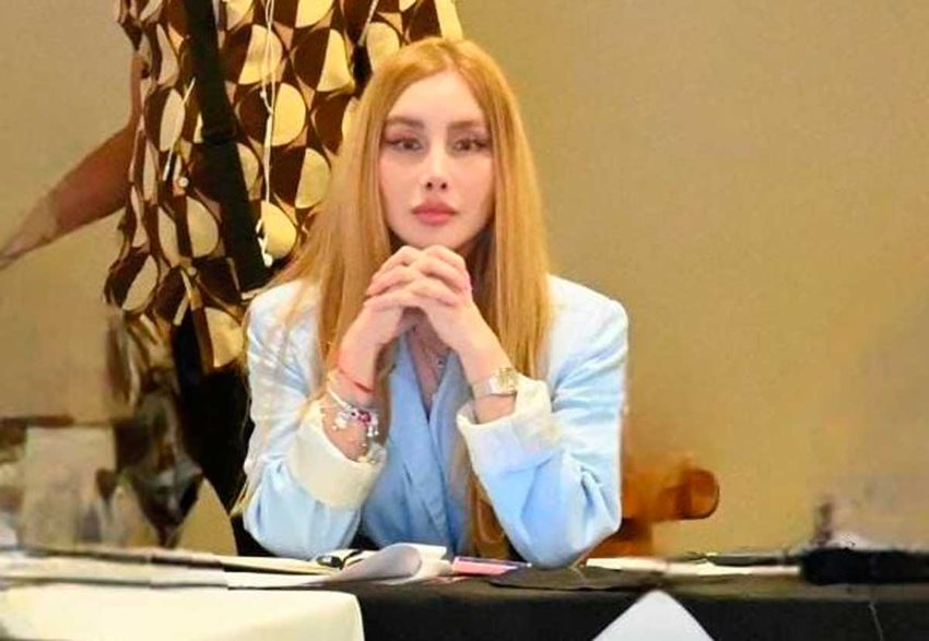 Ministra Diana Morales sentada, con las manos cruzadas bajo su mentón, prestando atención en medio de reunión.