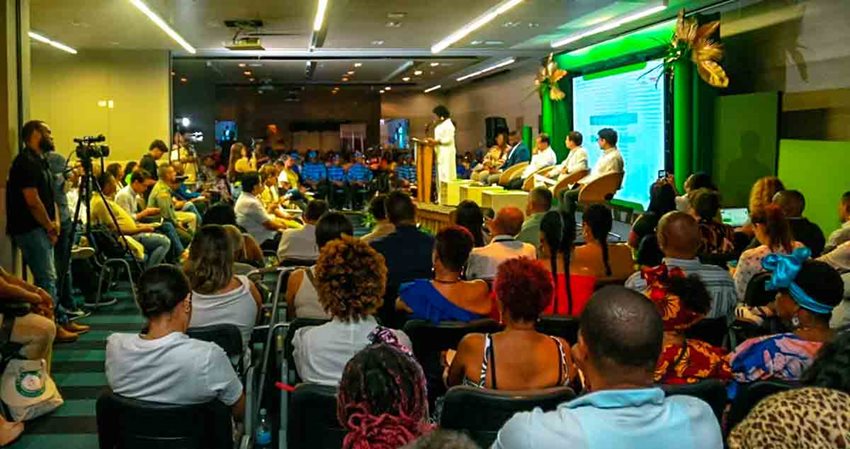 Descripción de la imagen: Personas en auditorio prestando atención a quienes están en el escenario.