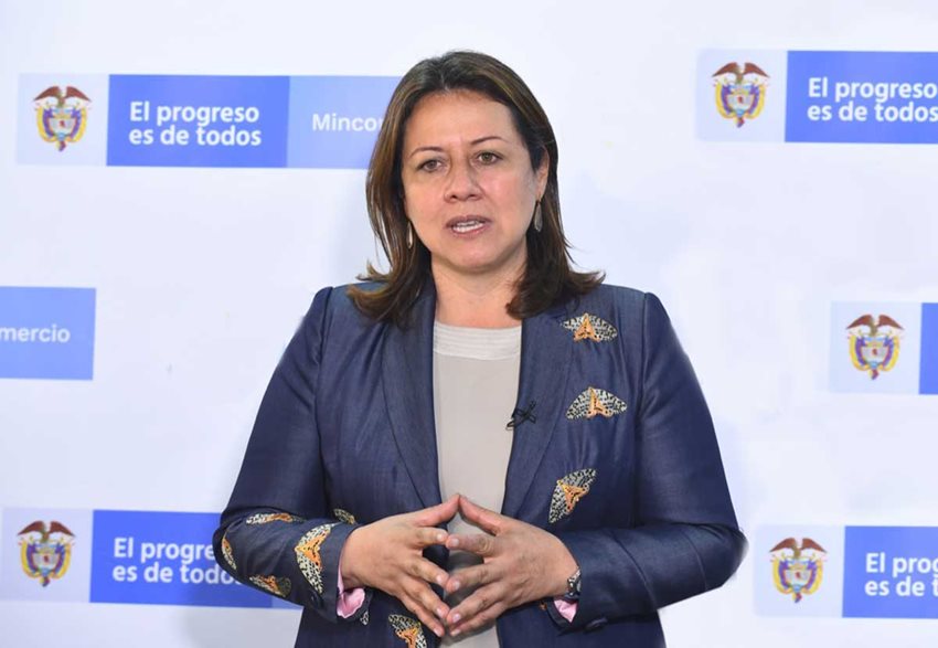 Ministra de Comercio, Industria y Turismo, Ximena Lombana, dando declaraciones a prensa con logo Mincomercio.