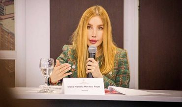 Ministra Diana Morales hablando por micrófono desde una mesa. - Ventanilla Única de Inversión (VUI) hizo su debut ante más de 4.000 empresarios en Macrorrueda de Las Américas