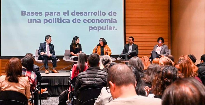 Personas participando en un seminario como conferencistas y público.