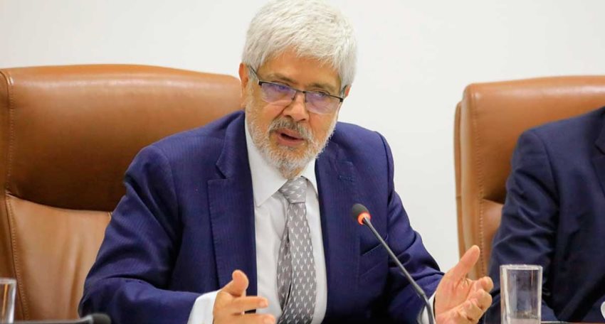 Ministro Germán Umaña, con traje y hablando al público por micrófono.