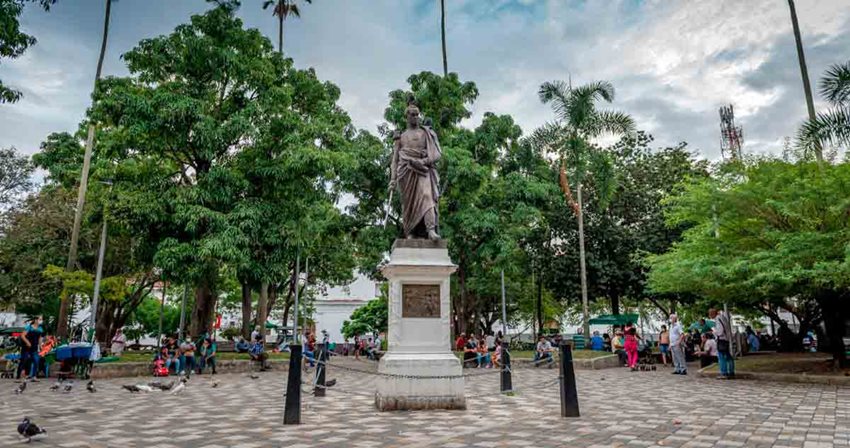 Fotografía de una estatua en la mitad de un parque principal.
