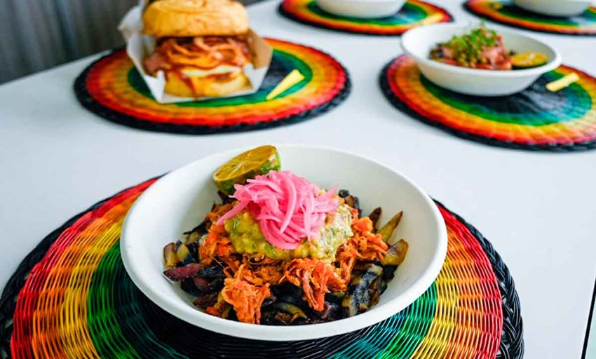 Tres platos con comida, servidos encima de manteles individuales artesanales. 