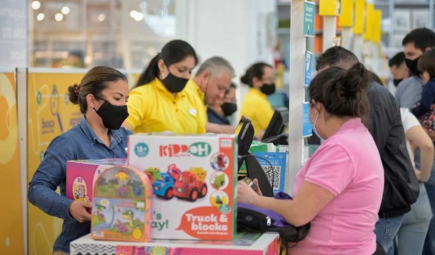 Personas pagando en caja juguetes que compraron en el tercer día sin IVA en un almacén de cadena.