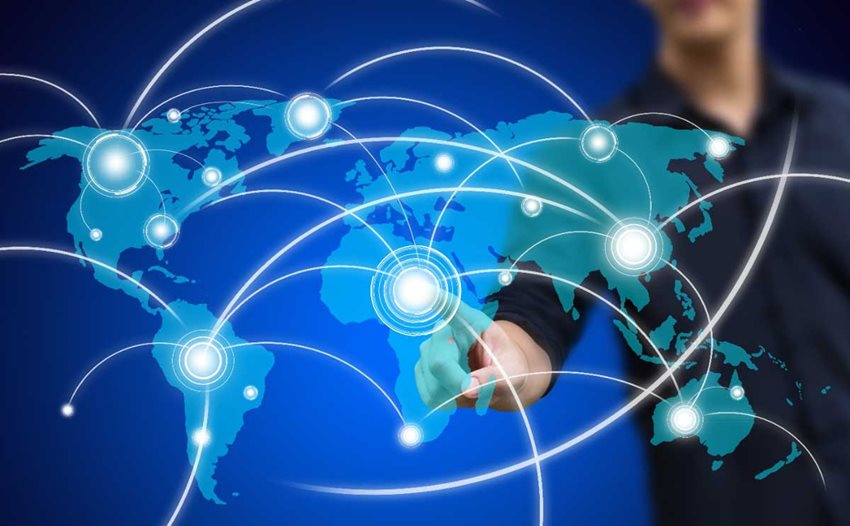 Hombre señalando con su dedo un mapa mundi, mientras se forman extensiones o luces a lo ancho del mapa.