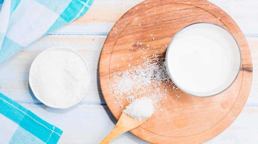 Leche en polvo en un recipiente de madera sobre una tabla de madera.