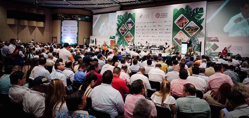 Personas reunidas en auditorio prestando atención a los ponentes.