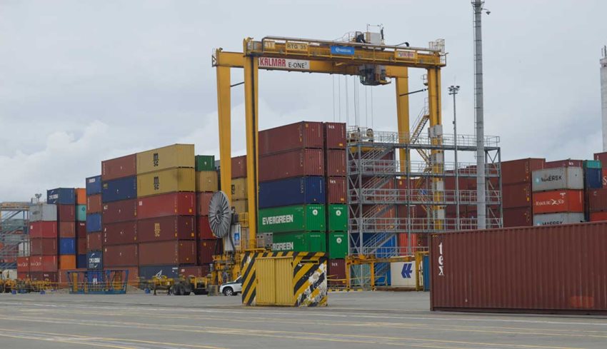Contenedores de colores descargados en calle de puerto.