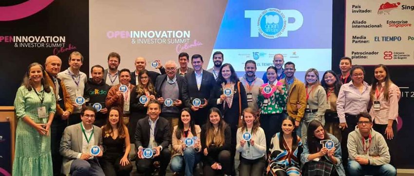 Hombres y mujeres en el escenario recibiendo premio y reconocimiento.