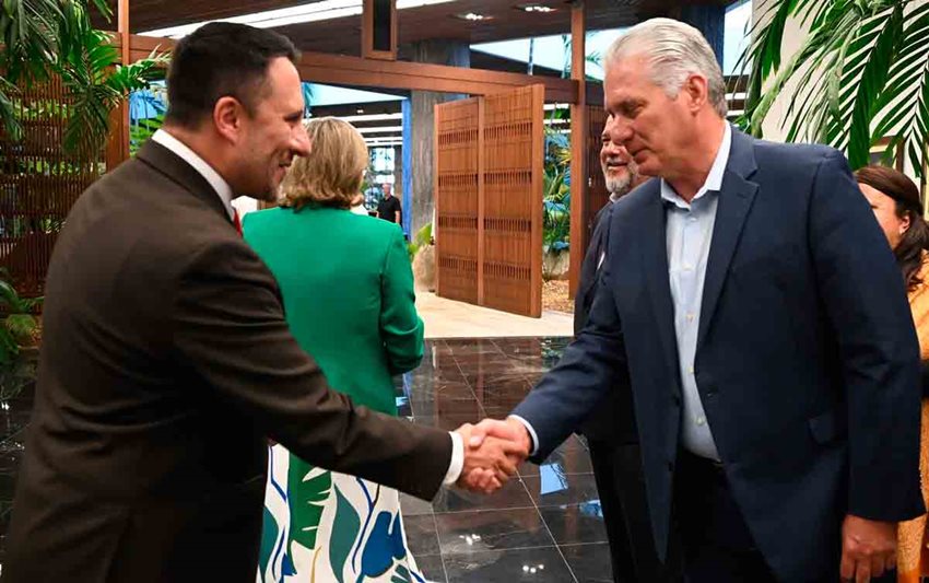 Dos hombres, en traje, dándose la mano en forma de saludo.