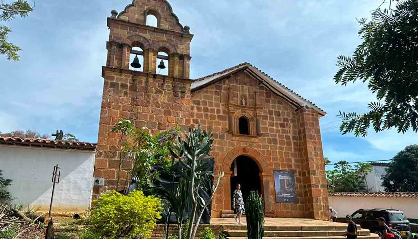 Descripción de la imagen: Fachada de iglesia, en ladrillos cafés, con personas al frente tomándose fotos.