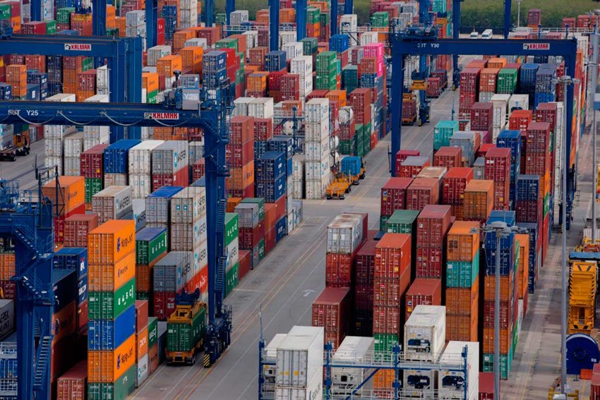 Contenedores de colores descargados en medio de la calle de un puerto.