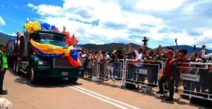 Dos-anos-del-restablecimiento-de-relaciones-con-Venezuela-y-Colombia.jpg Personas observando camión decorado con bombas y bandera de Colombia, que va pasando por vía del puente.