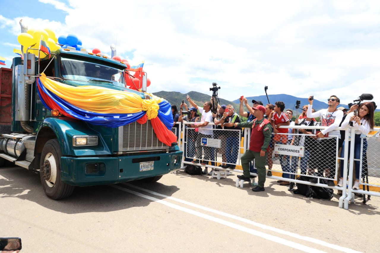 Camión, con bandera de Venezuela, transitando por el puente.